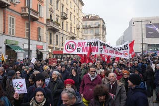 Protesters carry signs as they march through Milan